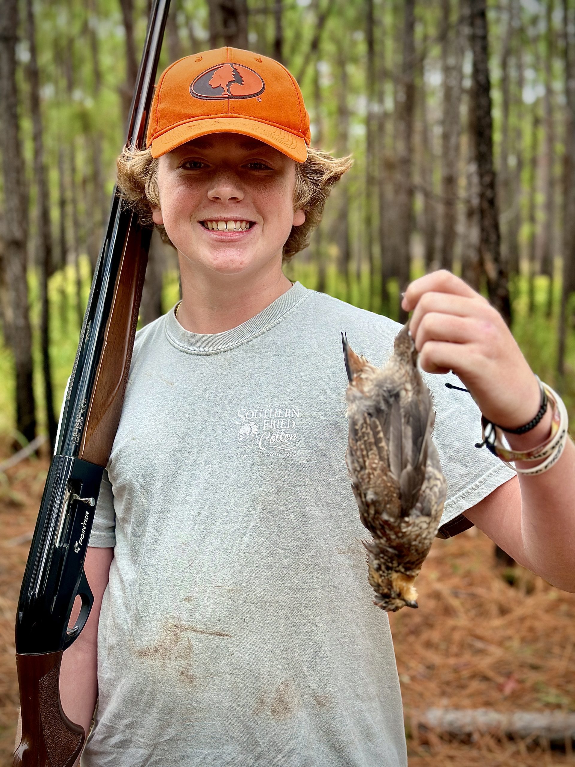 teen holding quail and shotgun